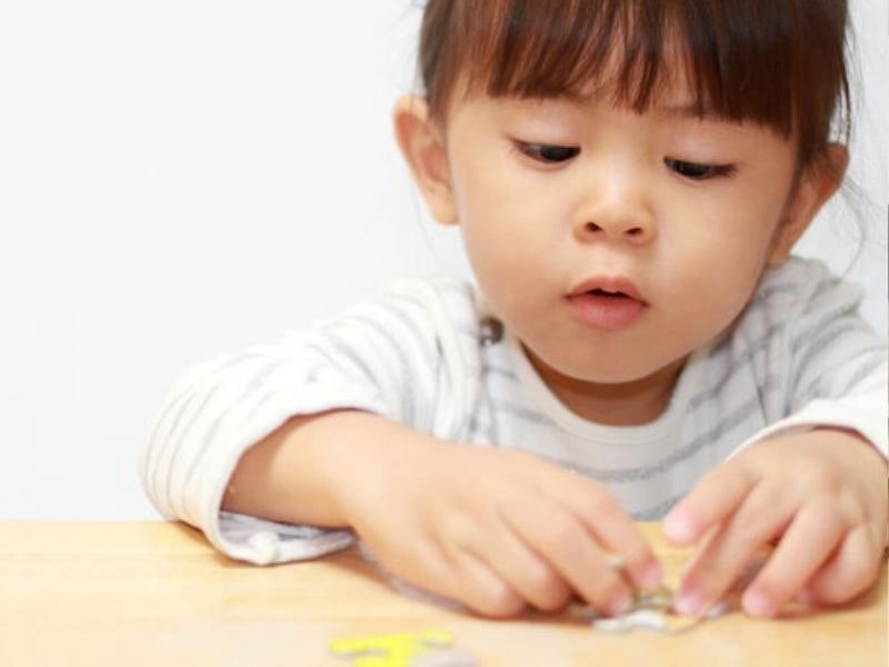 A young girl playing with a puzzle