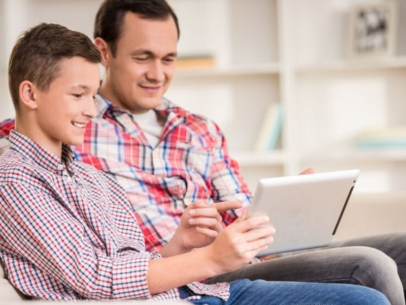 A father and son looking at a tablet